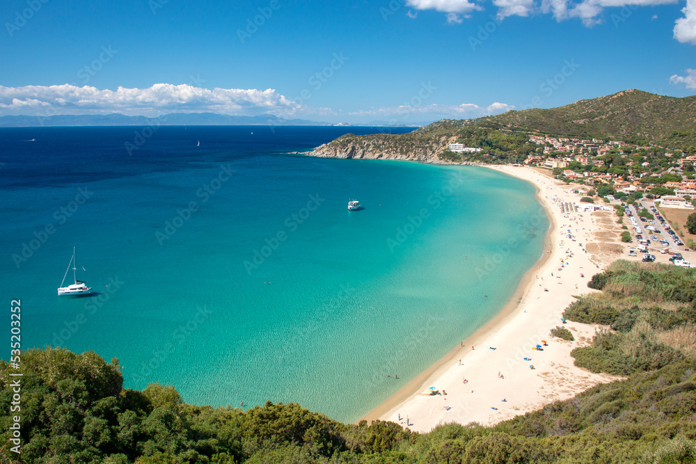 Aerial view on the beach Solanas with white sand, hills with green vegetation, sea with blue transparent water and village in the province Sinnai. Location Sardinia, Italy.
