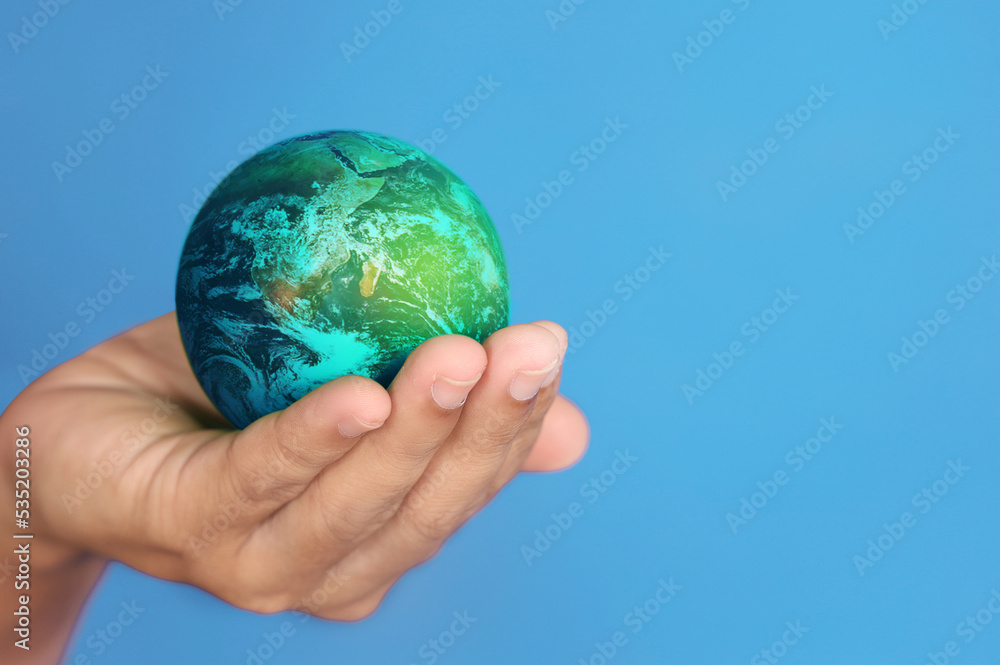 Hand hold globe with blue background.Elements of this image furnished by NASA Hand hold globe with blue background.Elements of this image furnished by NASA