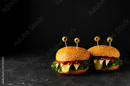 Funny party halloween monster burger on black background, halloween festive