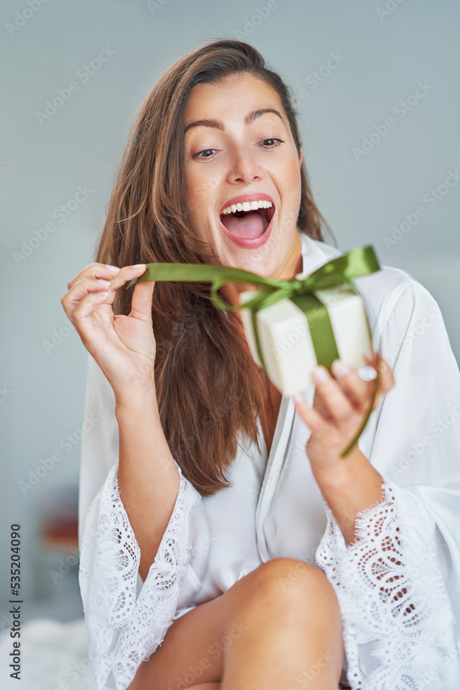 Sexy brunette woman on bad having gift box Sexy brunette woman on bad having gift box
