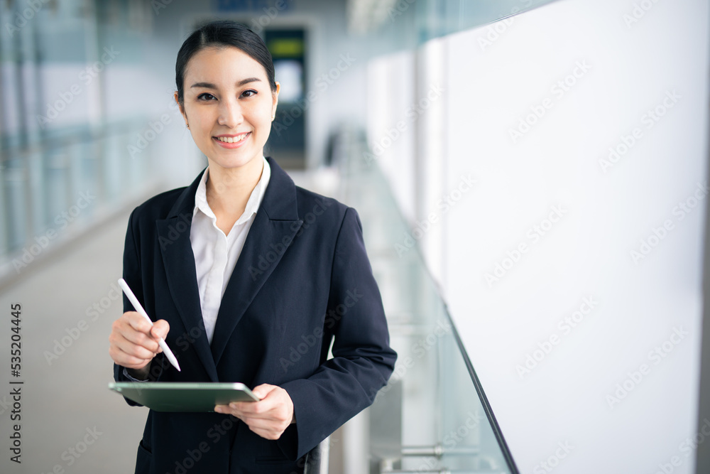 Asian business woman holding a tablet looking smile , smart business concept, smart woman . Asian business woman holding a tablet looking smile , smart business concept, smart woman .