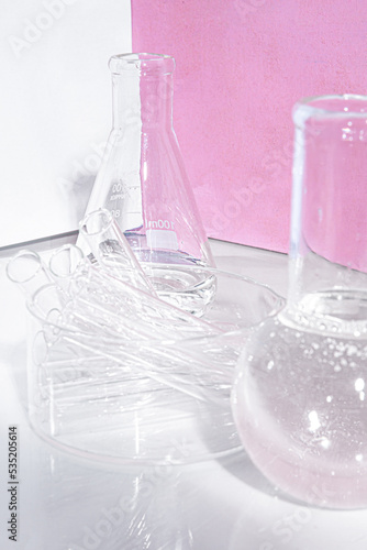 Transparent glass flask on a pink background. science research chemistry banner laboratory background.