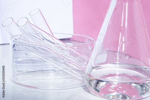 Transparent glass flask on a pink background. science research chemistry banner laboratory background.
