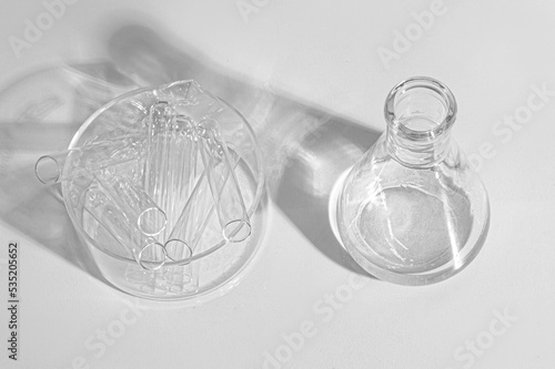 Transparent glass flask on a white background. science research chemistry banner laboratory background. Serum with a pipette in the laboratory. Cosmetic research.
