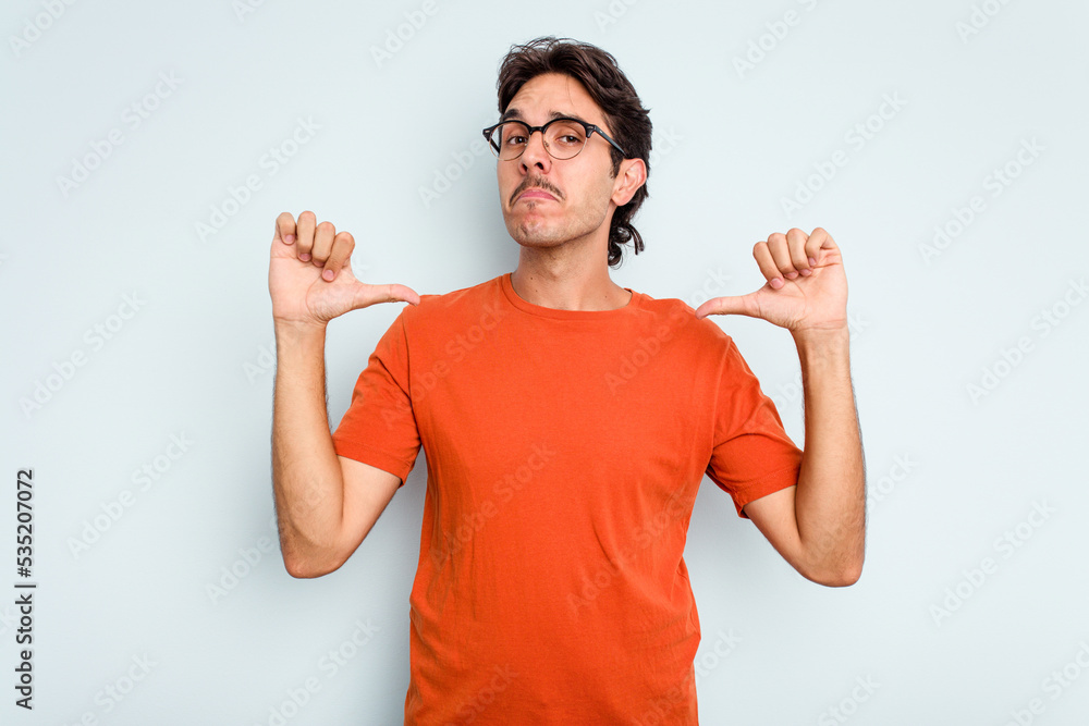 Young hispanic man isolated on blue background feels proud and self confident, example to follow. Young hispanic man isolated on blue background feels proud and self confident, example to follow.
