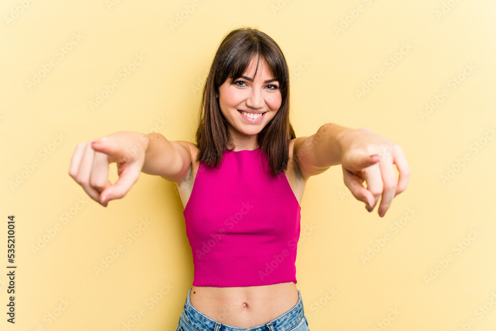 Young caucasian woman isolated on yellow background cheerful smiles pointing to front. Young caucasian woman isolated on yellow background cheerful smiles pointing to front.