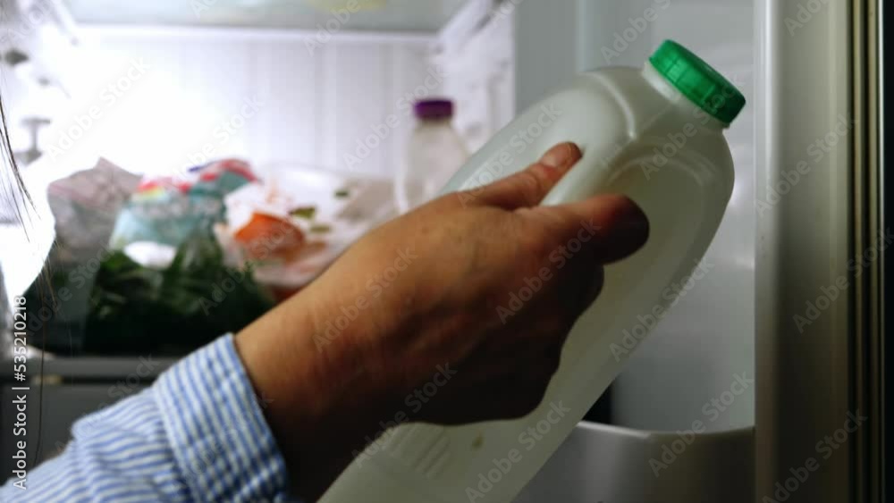 Looking in the refrigerator and making shopping list on cellphone Looking in the refrigerator and making shopping list on cellphone