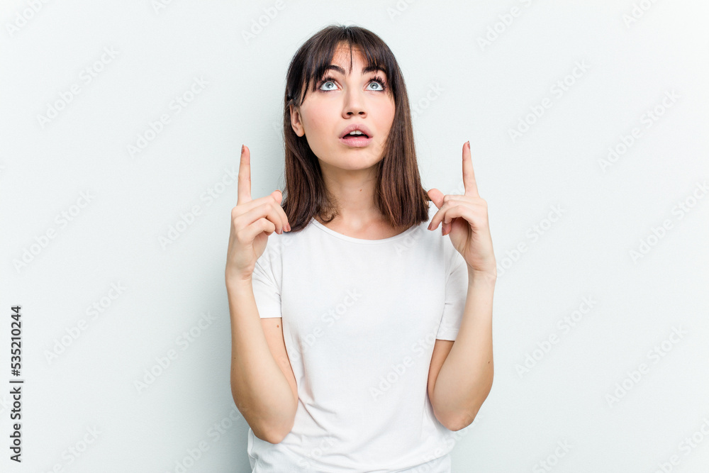 Young caucasian woman isolated on white background pointing upside with opened mouth. Young caucasian woman isolated on white background pointing upside with opened mouth.