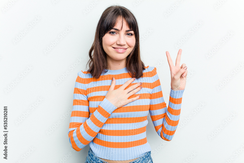 Young caucasian woman isolated on white background taking an oath, putting hand on chest.
