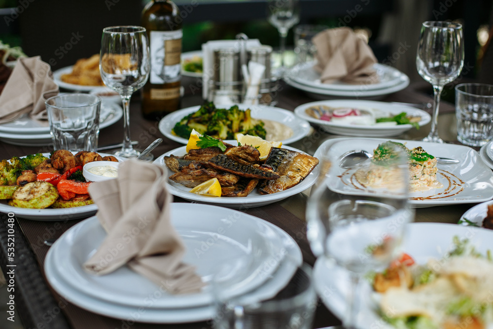 A table with beautiful dishes and prepared dishes on the summer terrace A table with beautiful dishes and prepared dishes on the summer terrace