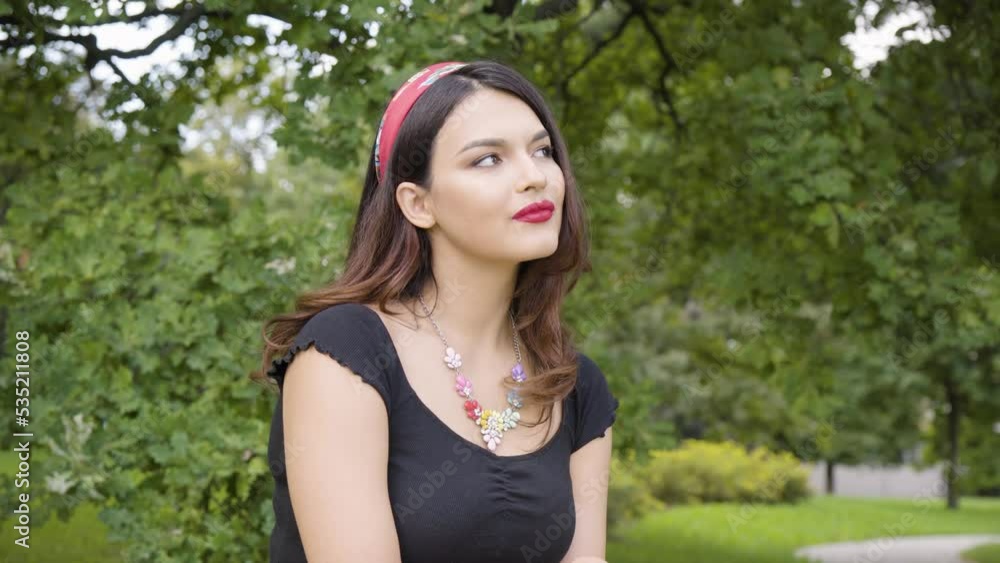 A young beautiful Caucasian woman thinks about something in a park on a sunny day A young beautiful Caucasian woman thinks about something in a park on a sunny day
