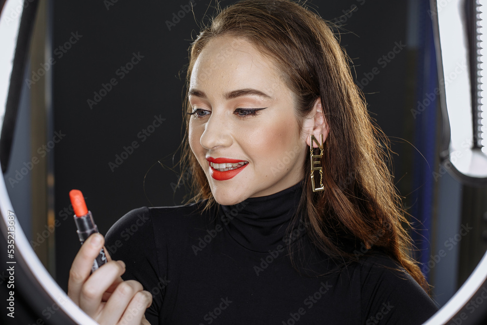 Obraz premium A girl with dark hair on a dark background with bright makeup