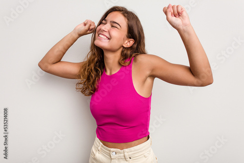 Young caucasian woman isolated on blue background celebrating a special day, jumps and raise arms with energy.