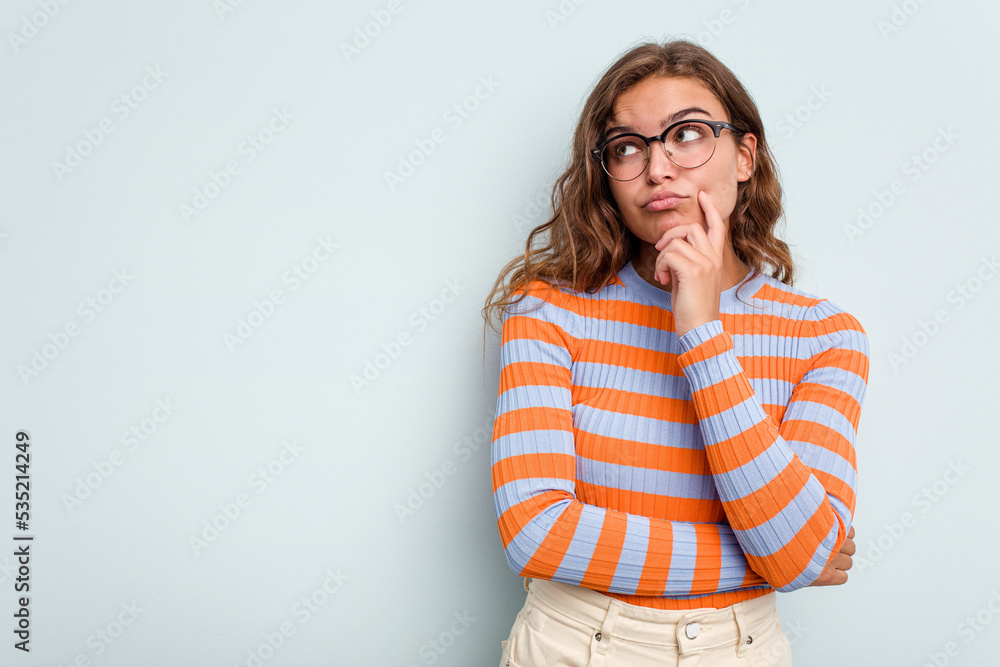 Young caucasian woman isolated on blue background looking sideways with doubtful and skeptical expression. Young caucasian woman isolated on blue background looking sideways with doubtful and skeptical expression.