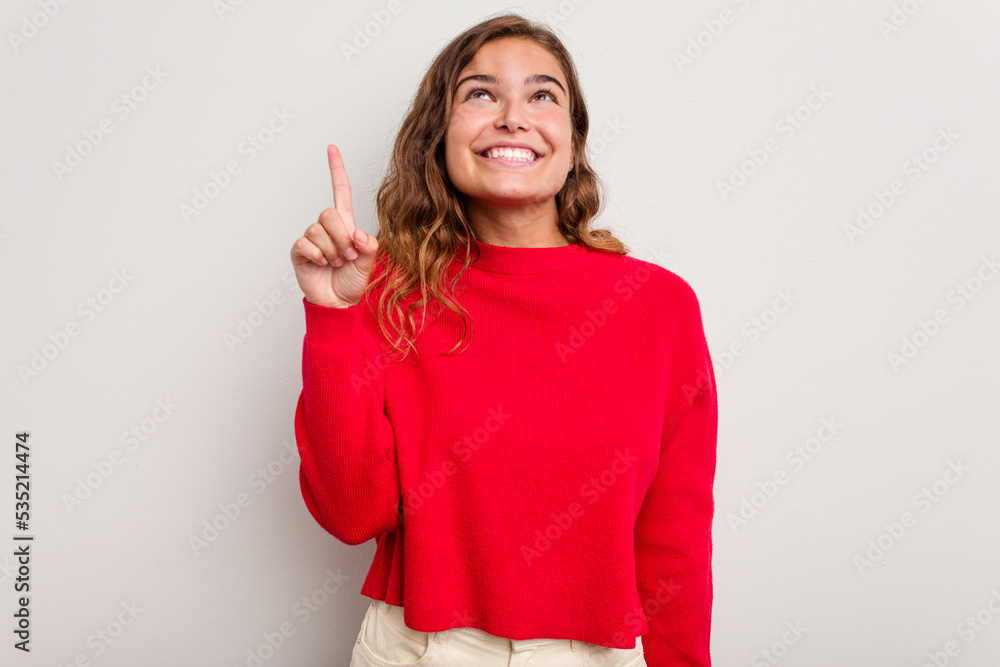 Young caucasian woman isolated on blue background indicates with both fore fingers up showing a blank space. Young caucasian woman isolated on blue background indicates with both fore fingers up showing a blank space.