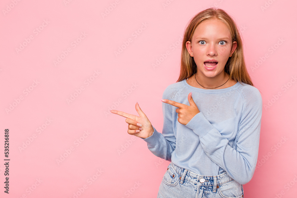 Caucasian teen girl isolated on pink background pointing with forefingers to a copy space, expressing excitement and desire. Caucasian teen girl isolated on pink background pointing with forefingers to a copy space, expressing excitement and desire.