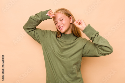 Caucasian teen girl isolated on beige background celebrating a special day, jumps and raise arms with energy. © Asier