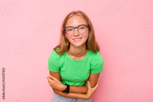 Caucasian teen girl isolated on pink background laughing and having fun.