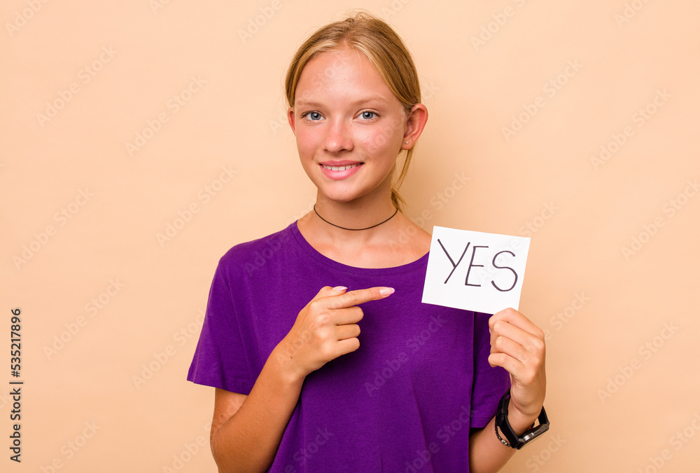 Little caucasian girl holding yes placard isolated on beige background Little caucasian girl holding yes placard isolated on beige background