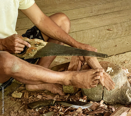 Java, Indonesia, June 13, 2022 - Man carves Tau Tau which are wooden effigies carved in Toraja to represent people who have died.