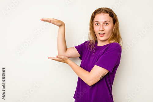 Wallpaper Mural Young caucasian woman isolated on white background shocked and amazed holding a copy space between hands. Torontodigital.ca