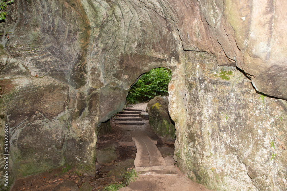 Huel Lee or Hohllay on the Mullerthal trail in Luxembourg, open cave with view to the forest, sandstone rock formation