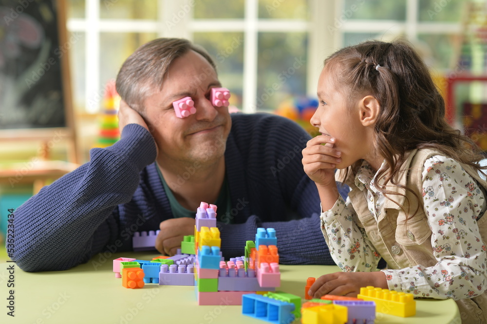 Portrait of father and daughter play with construct Portrait of father and daughter play with construct