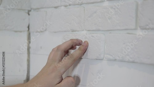 laying decorative embossed gypsum bricks on the wall. Modern apartment renovation photo