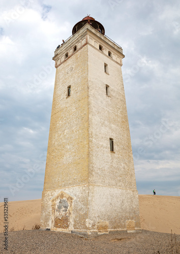 Lokken, Denmark - August 24, 2022: People at the popular Rubjerg Knude Lighthouse in Jutland. © michaklootwijk