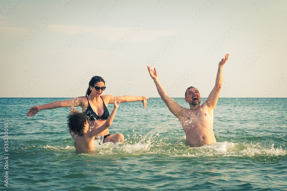 Dad, daughter and son bathe swimming in the sea and having fun together. Paternity concept Dad, daughter and son bathe swimming in the sea and having fun together. Paternity concept