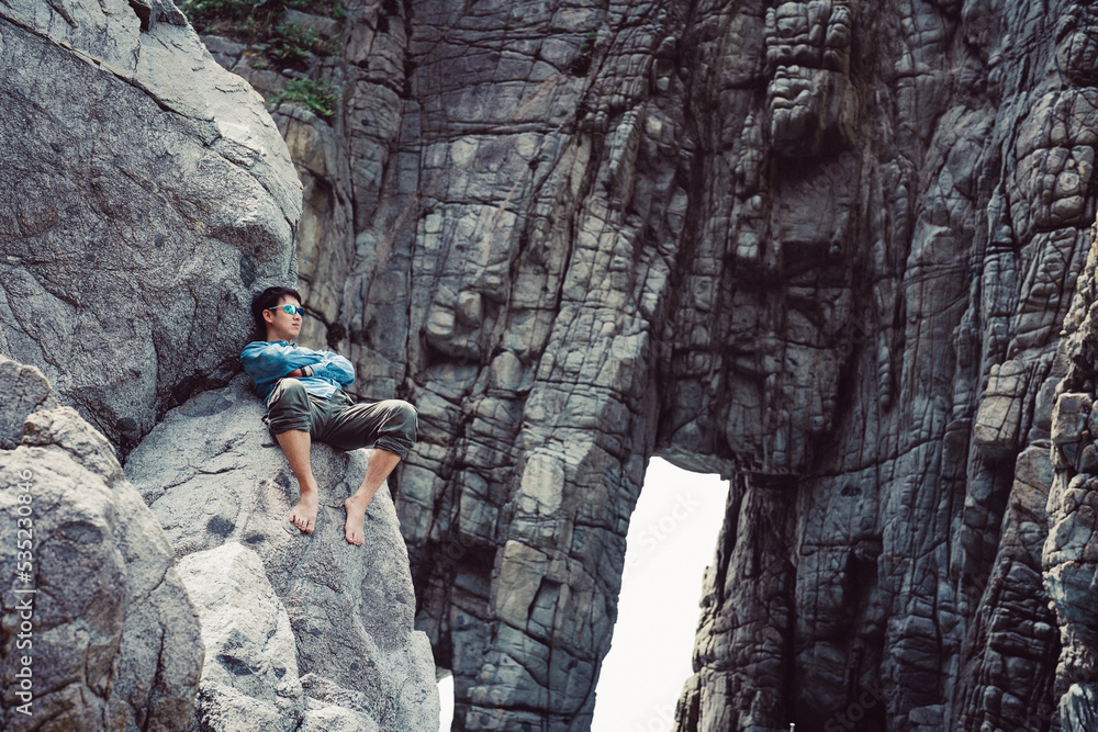Obraz premium 岩に座る男性
