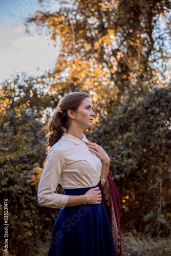 Romantic young beautiful lady in autumn forest. Victorian style vintage