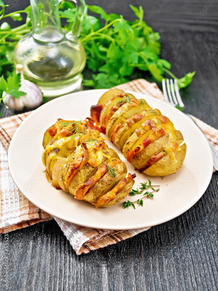 Potatoes with smoked bacon in plate on dark board Potatoes with smoked bacon in plate on dark board