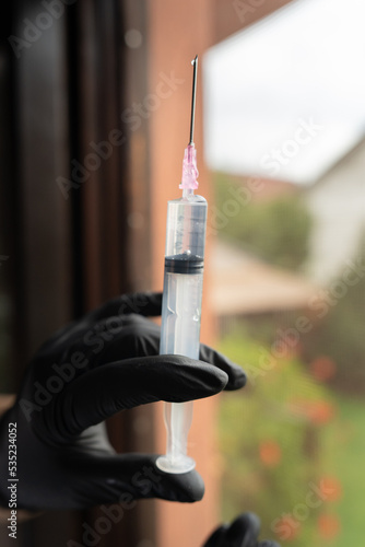 A close up of needle using cure from bottle preparing for vaccination 