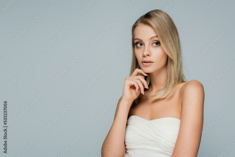 pensive woman with bare shoulders and natural makeup looking away isolated on grey. pensive woman with bare shoulders and natural makeup looking away isolated on grey.