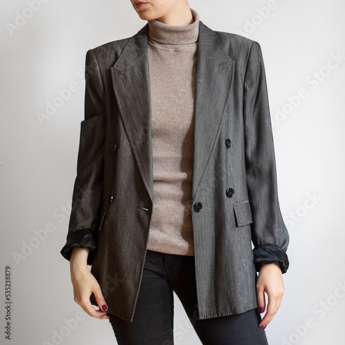 Canvas Print Woman wearing oversized grey blazer, beige turtleneck and black skinny jeans iso