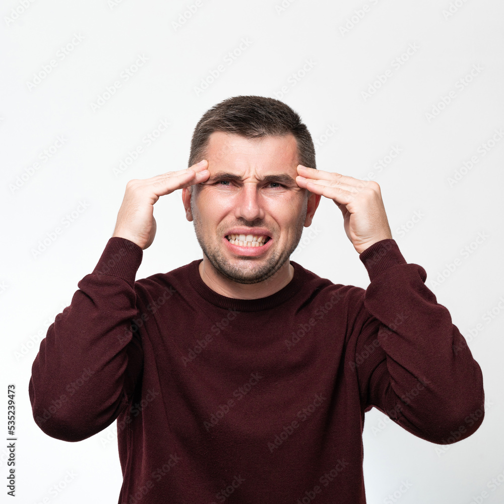 Emotions of a man from a headache, a man suffers from the pain of a severe migraine. Emotions of a man from a headache, a man suffers from the pain of a severe migraine.