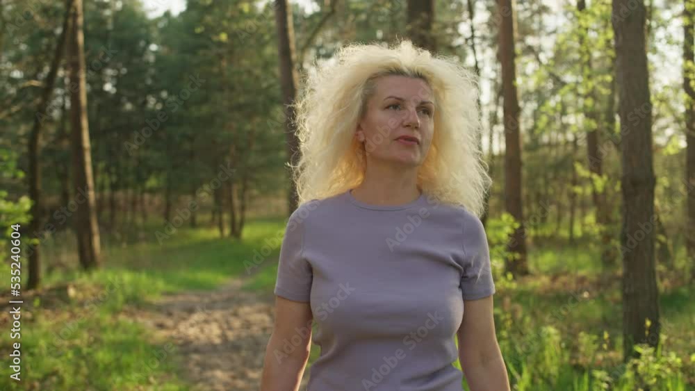 Portrait of a beautiful senior woman walking in the park. Happy smiling man. Cardio while walking. High quality 4k footage Portrait of a beautiful senior woman walking in the park. Happy smiling man. Cardio while walking. High quality 4k footage