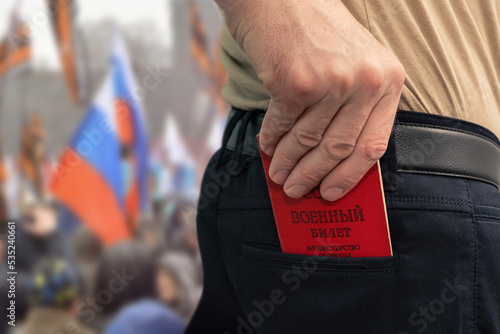 Man puts a military ID in the back pocket of his trousers. Mobilization in the Russian Federation. Contract service. The inscription on the document - 