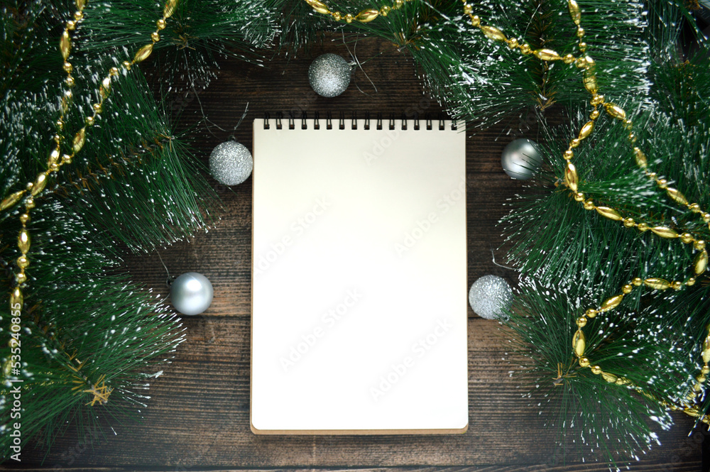 Blank white notebook on dark wooden background with fir branches and silver ball Blank white notebook on dark wooden background with fir branches and silver ball