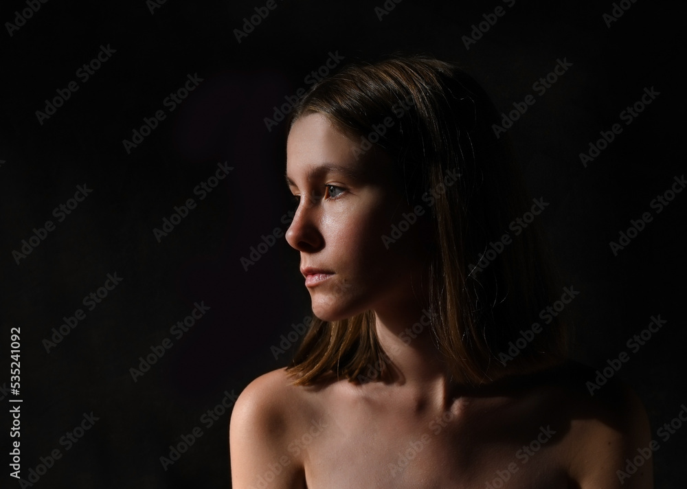 Low key portrait of a young cute girl in profile Low key portrait of a young cute girl in profile