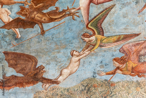 Fototapeta Detail of medieval fresco showing angels and demons fighiting while flying in th