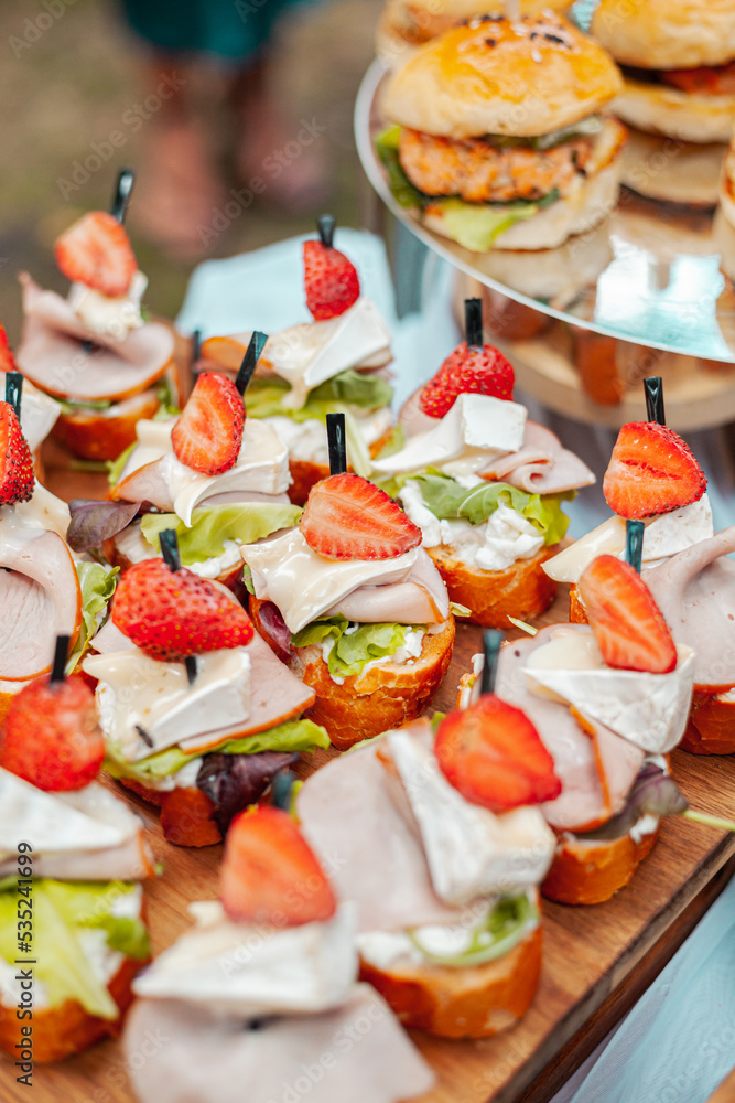 Sandwiches with camembert ham and strawberries on a wooden board Sandwiches with camembert ham and strawberries on a wooden board