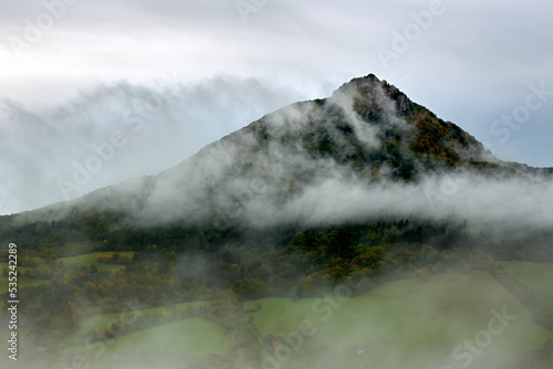 Autumn misty landscape with valley and beautiful hill after rain. Early morning. View from above. Vapec, Slovakia.