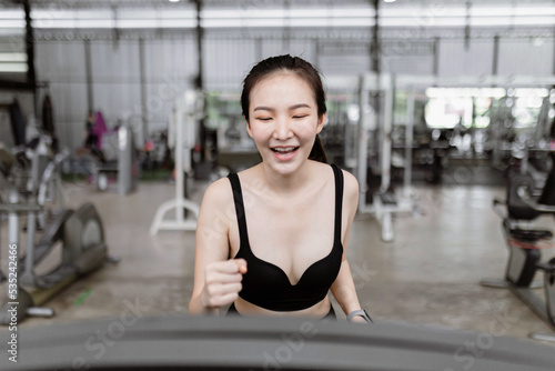 exercise concept The female runner standing and being about to start the treadmill to work on with happy and smiling face