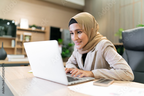 Happy Business Muslim hijab woman work. Cheerful female Islam person thinks while working at a workplace office. occupation focus on Arabic worker thinking or finding motivation for working in office