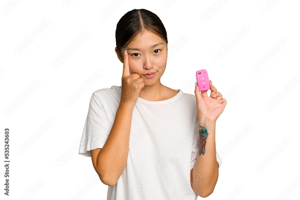 Young asian woman holding car keys isolated on green chroma background pointing temple with finger, thinking, focused on a task. Young asian woman holding car keys isolated on green chroma background pointing temple with finger, thinking, focused on a task.