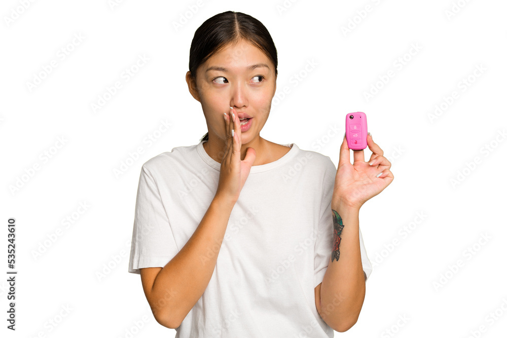 Young asian woman holding car keys isolated on green chroma background is saying a secret hot braking news and looking aside Young asian woman holding car keys isolated on green chroma background is saying a secret hot braking news and looking aside