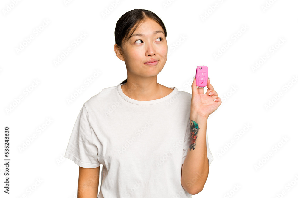 Young asian woman holding car keys isolated on green chroma background dreaming of achieving goals and purposes Young asian woman holding car keys isolated on green chroma background dreaming of achieving goals and purposes
