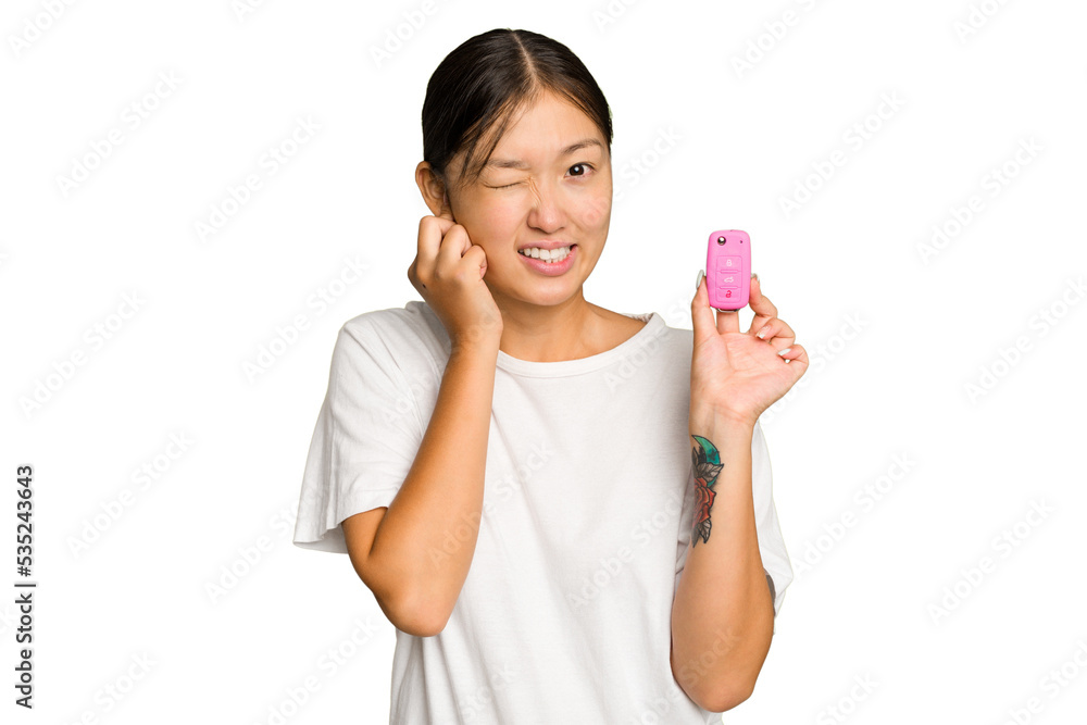 Young asian woman holding car keys isolated on green chroma background covering ears with hands. Young asian woman holding car keys isolated on green chroma background covering ears with hands.